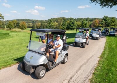 Golf fundraiser attendants pulling up to course in carts